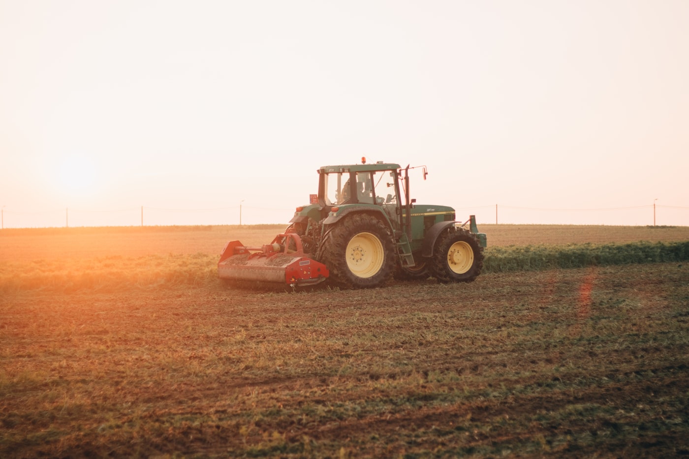 Tractor working a field at sunset